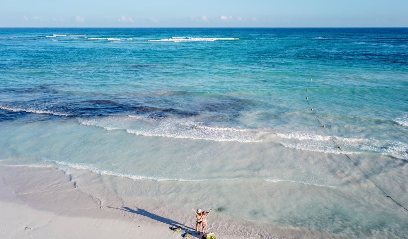 La viajera solista Kristin Addiss a México con una amiga en la playa mirando el agua