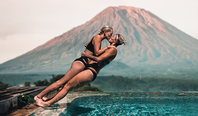 Charlotte y Natalie sumergiéndose en una piscina frente a un volcán en Bali