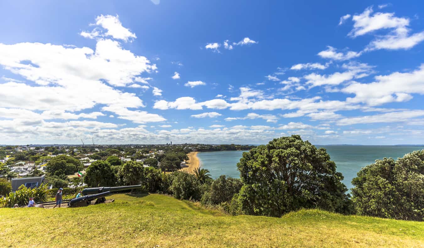 Gente caminando por la colina hierba de Devonport con vistas a Auckland, Nueva Zelanda