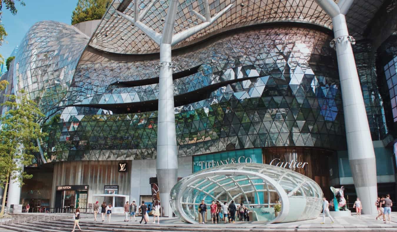 Un centro comercial de lujo de diseño moderno con carteles para Cartier, Tiffany's y Louis Vuitton en Orchard Road, Singapur