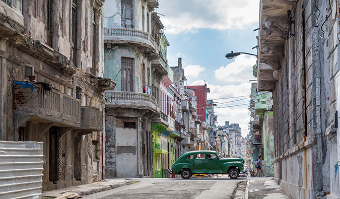 un coche verde que pasa por una calle de La Habana