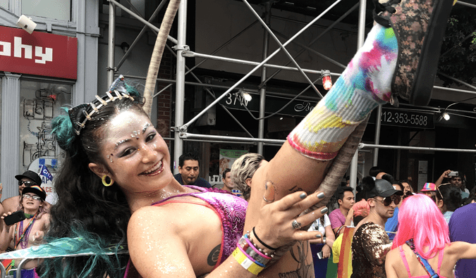 una mujer con un hula hoop y vestida de purpurina durante el desfile del orgullo gay