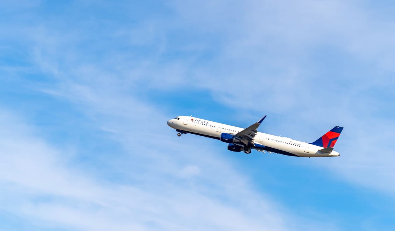 Un avión Delta subiendo a un cielo azul brillante tras el despegue en EE.UU.