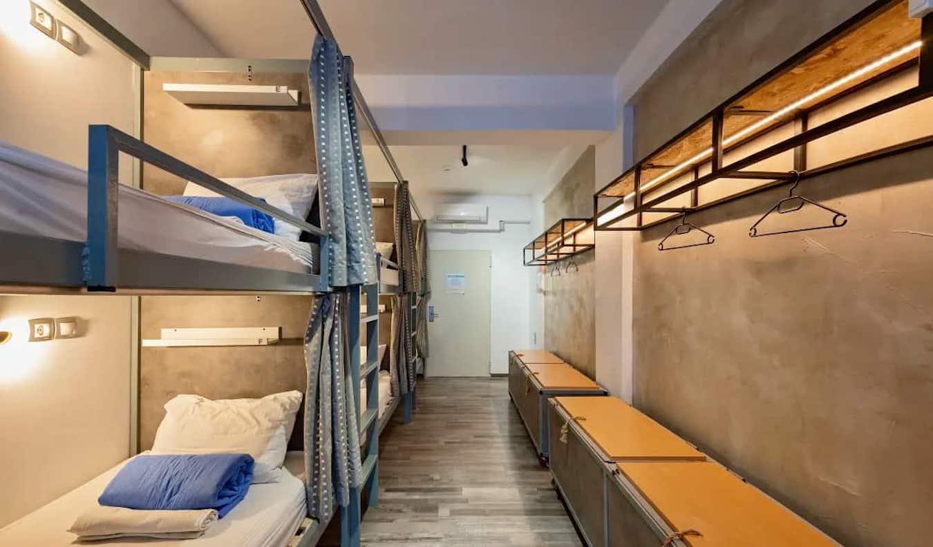 Camas acogedoras con cortinas en un dormitorio del albergue Bedbox de Atenas