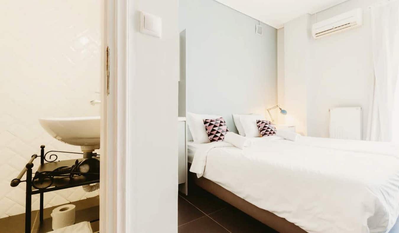 Una habitación privada espaciosa en Athens Studios en Grecia, con una cama grande y blanca