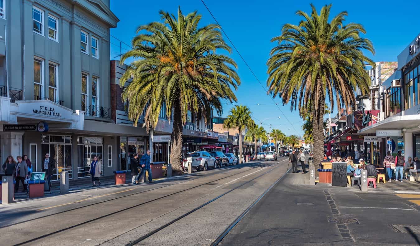 Gente relajándose en una calle de St Kilda, Melbourne, en un día luminoso y soleado