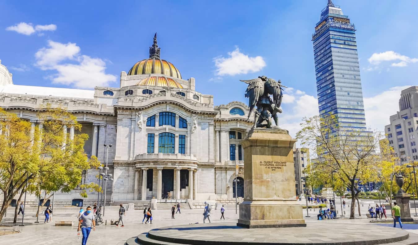 Gente que disfruta de un día soleado cerca de edificios históricos en Ciudad de México, México