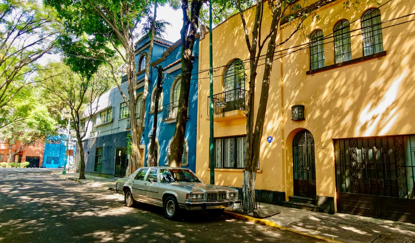 Una calle tranquila con casas de colores en Condesa, Ciudad de México, con un coche aparcado en la calle