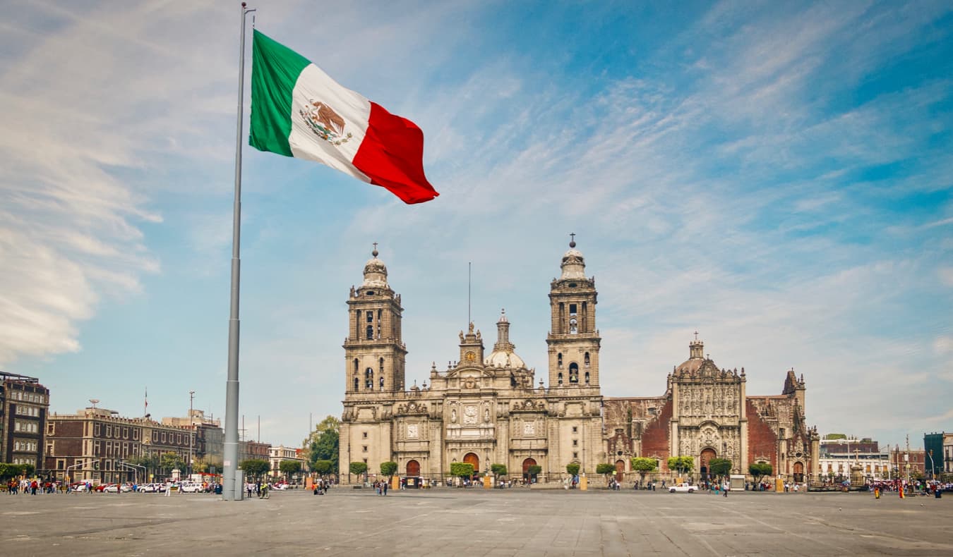 Una gran bandera mexicana frente a uno de los muchos edificios históricos de la Ciudad de México, México