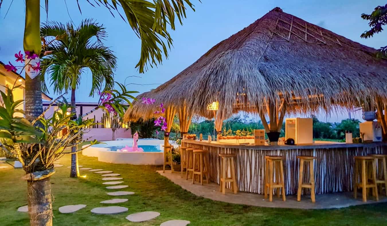 La piscina al aire libre y un pequeño bar en un día soleado en el albergue Clandestino en Canggu, Bali