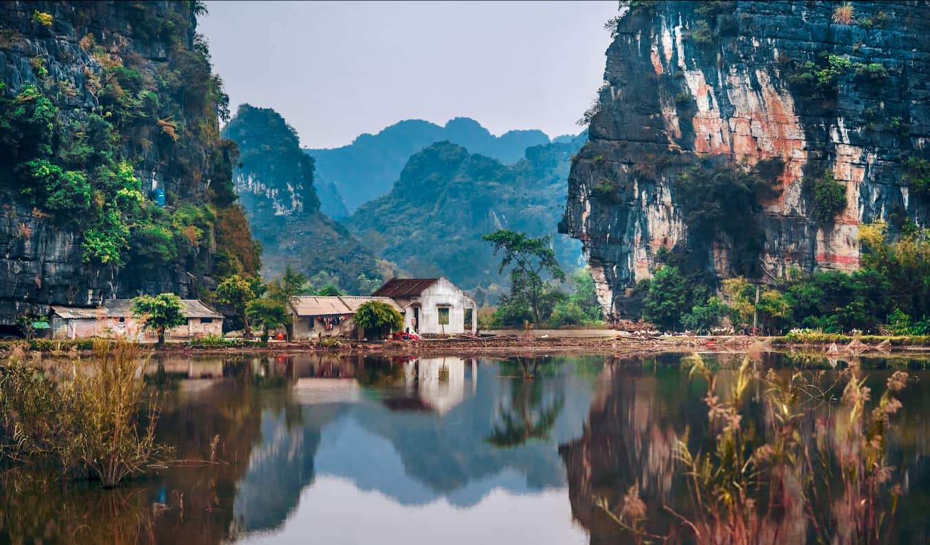 Un pequeño edificio situado contra las montañas cerca de un lago en las zonas rurales de Vietnam