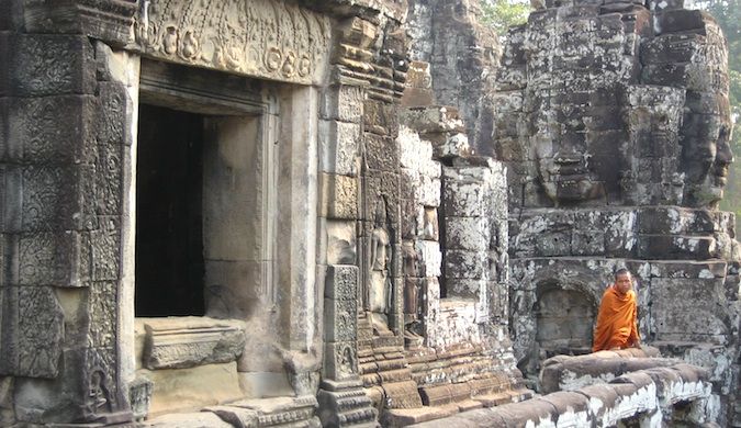 Un monje con su túnica deambulando por uno de los muchos templos antiguos de Angkor Wat en Camboya