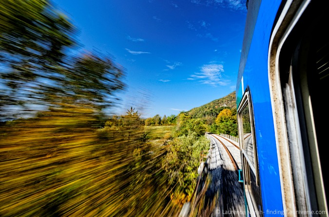 Foto de un tren rápido que pasa por un paisaje exuberante