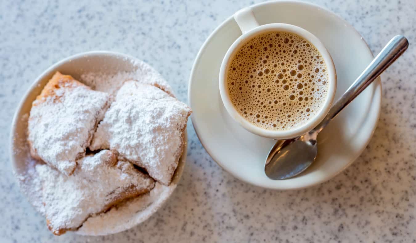 Un café y pequeños aperitivos fritos sobre una mesa en Nueva Orleans, EE.UU.