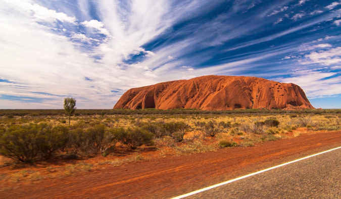 La famosa roca de Uluru en Australia, vista desde la carretera cercana