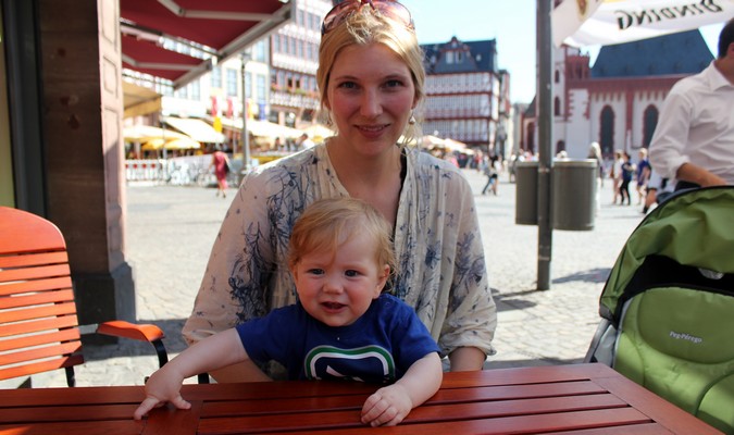 Mamá y su niño sentados en una mesa de picnic roja fuera de Europa