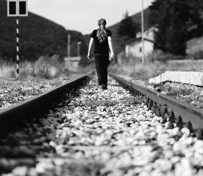 Autorretrato en blanco y negro de Laurence caminando por las vías del tren