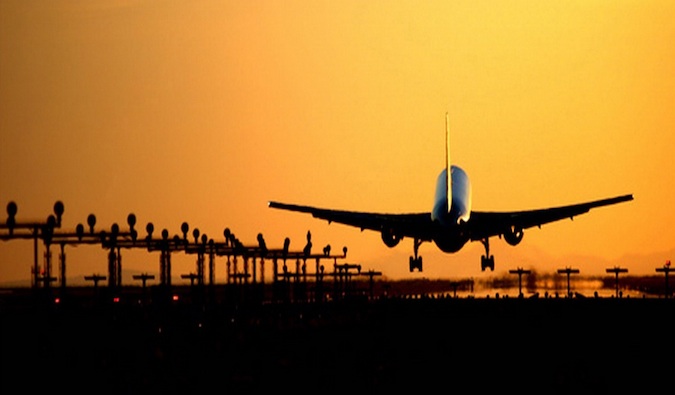 Un avión comercial que despega hacia la puesta de sol dorada y brillante