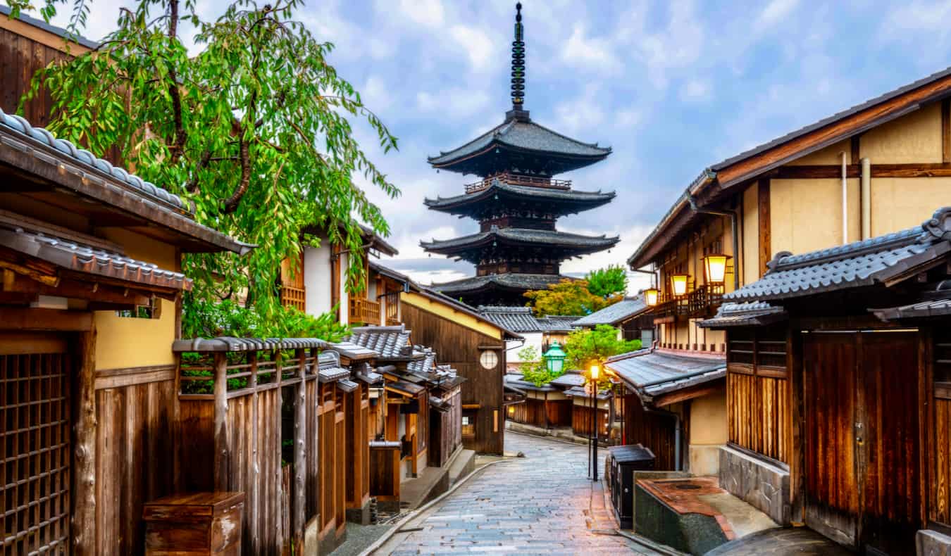 Una calle estrecha y antigua de la tranquila Kyoto, Japón con una pagoda a lo lejos