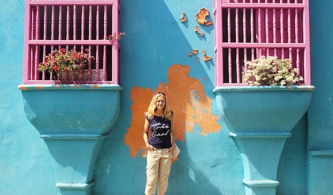 Viajera lesbiana sola poniendo cerca de una pared de colores