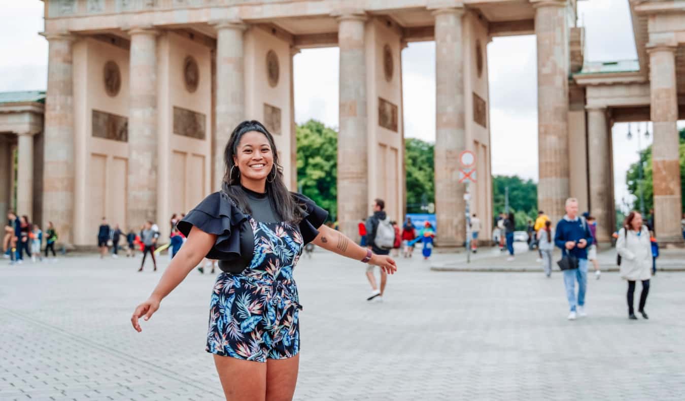 Ava viajera ávido poniendo cerca de la Puerta de Brandeburgo en Berlín, Alemania