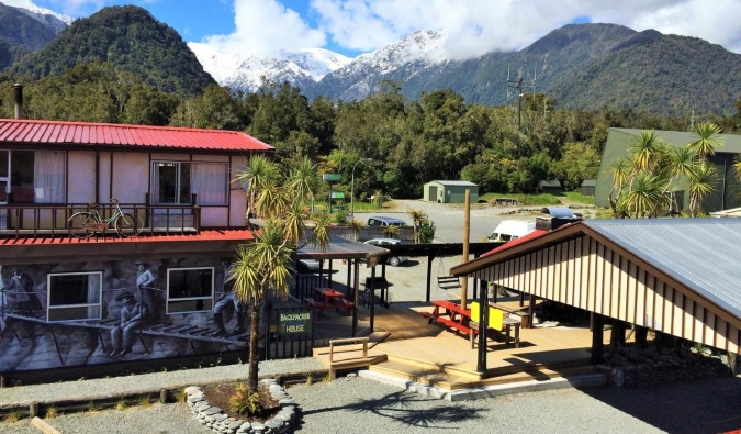 Exterior del alojamiento económico Chateau Backpacker & Motels con bosque al fondo, en Franz Josef, Nueva Zelanda