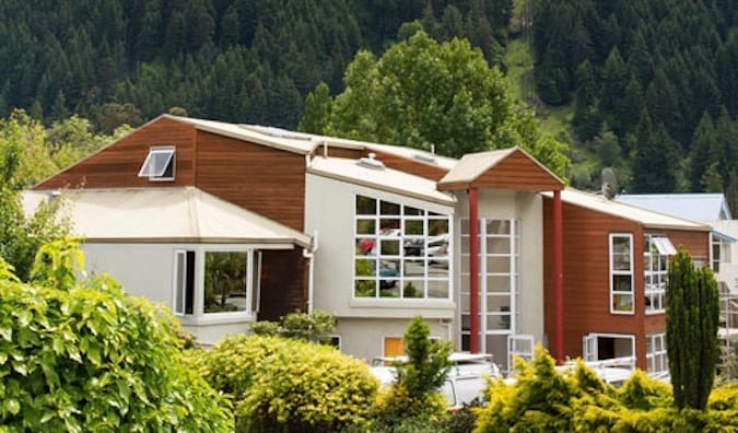 exterior del Haka Lodge de madera y de aspecto moderno, situado en un bosque de Nueva Zelanda