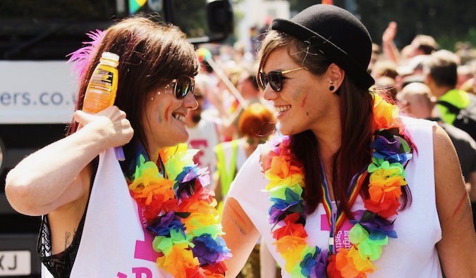 Lesbianas en el Pride cubriéndose con pintura y banderas