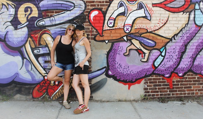pareja apoyada en la pared con arte callejero