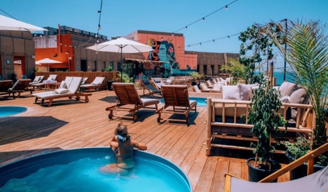 Mujer descansando en la piscina de la azotea del albergue Selina en Tel Aviv, Israel