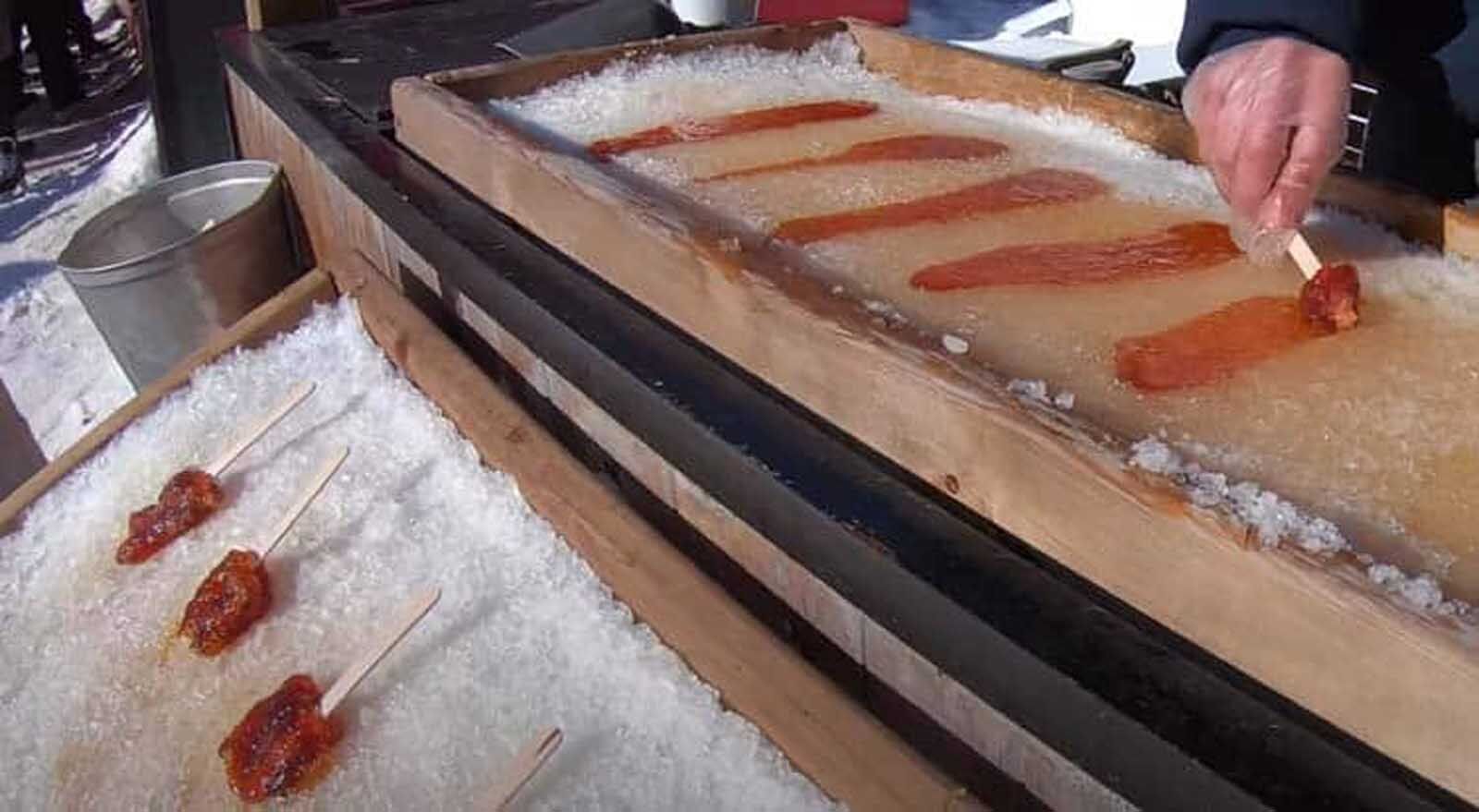 comida tradicional canadiense hirviendo jarabe de arce en la nieve