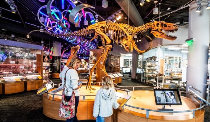 Una madre y una hija se encuentran frente a un esqueleto de dinosaurio en el Museo de Ciencias Naturales de Raleigh, Carolina del Norte