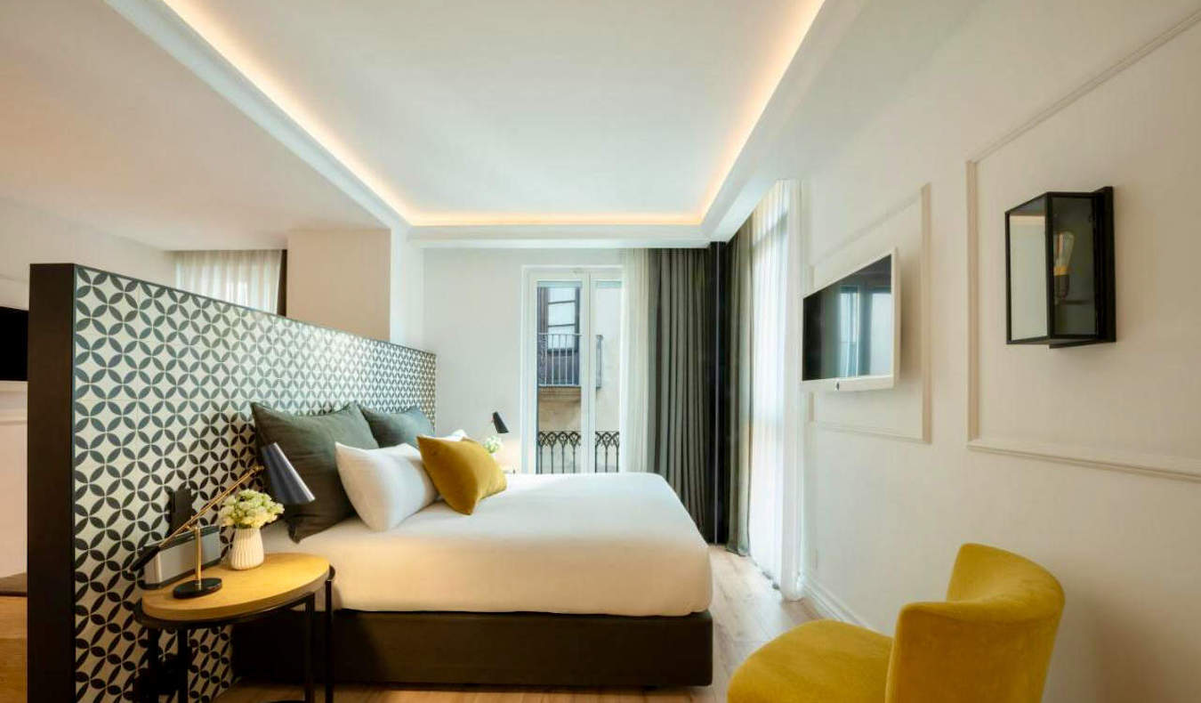 Una cama grande en una confortable habitación de hotel en Serras en Barcelona, ​​España