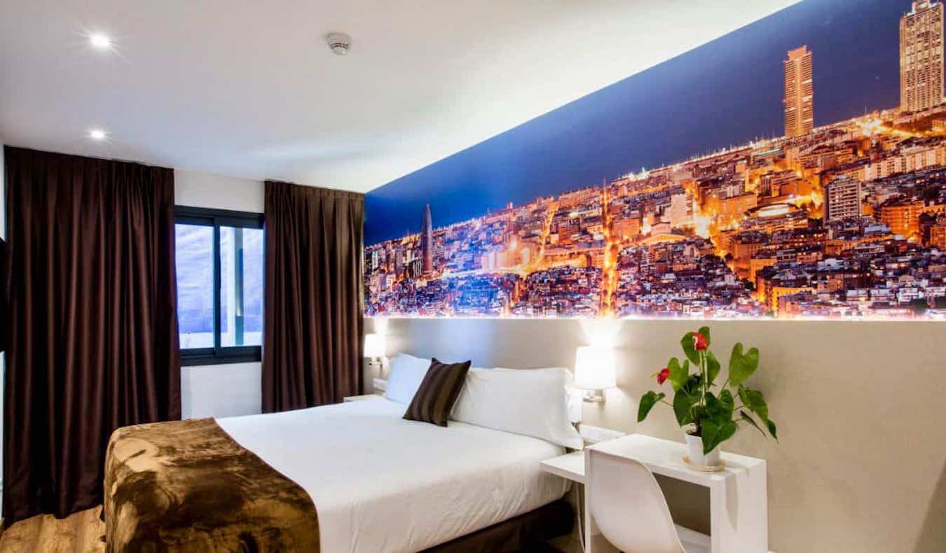 Una gran habitación de hotel con una gran fotografía de la ciudad en el Hotel BestPrice de Barcelona, ​​España