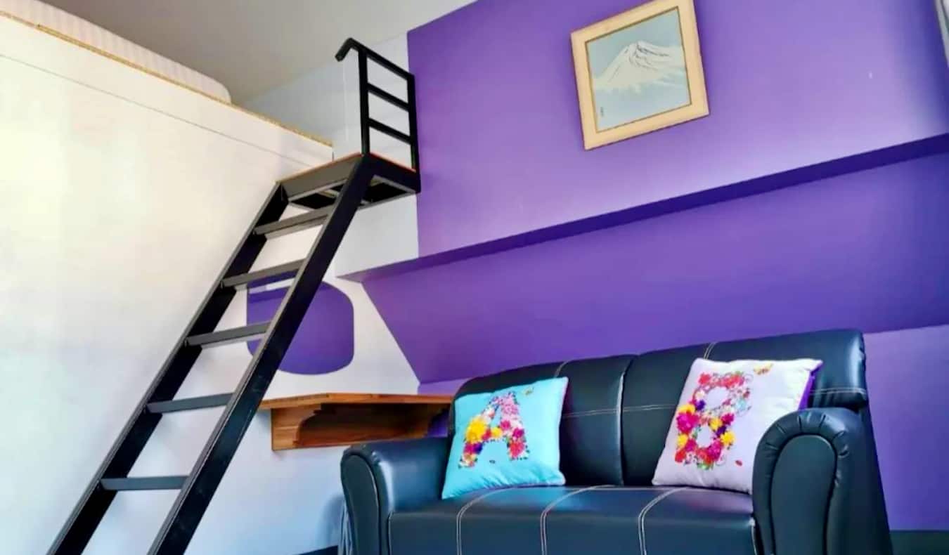 Una moderna habitación pintada de violeta en el albergue Dozy House en Chiang Mai, Tailandia