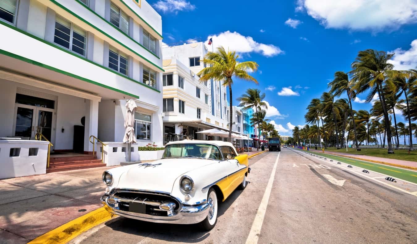 Un viejo coche colorido de los años 60 en la calle frente a los edificios Art Déco de South Beach en Miami, Florida