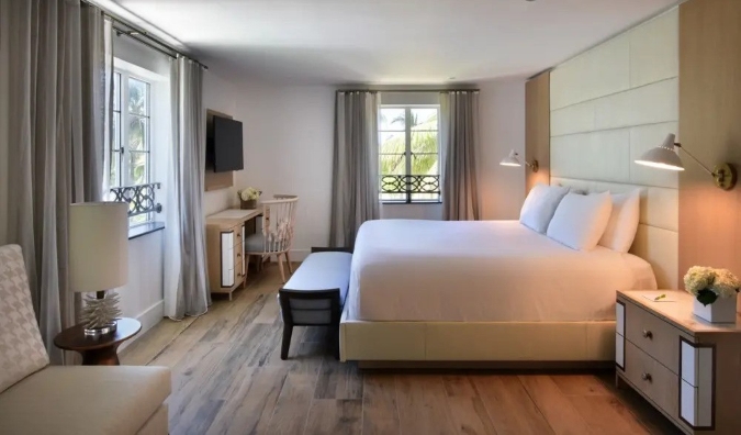 Habitación de hotel del Hotel Ocean de Miami, con una cama grande y escritorio y decorada en tonos cálidos y neutros