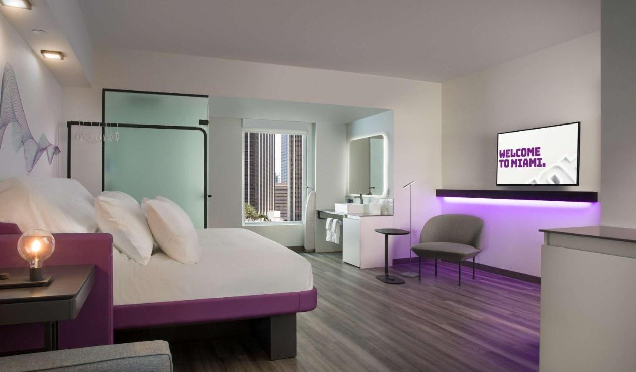 Habitación de hotel de diseño mínimo con tonalidades moradas en el Yotel de Miami, Florida