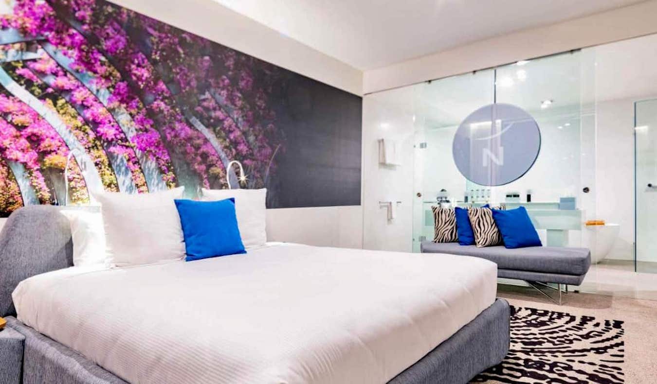 Una cama enorme en una amplia habitación de hotel en el hotel Novotel de Brisbane, Australia