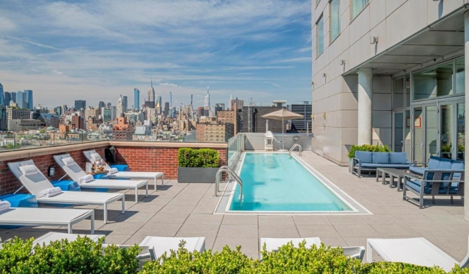 Piscina en la azotea con el horizonte de Nueva York al fondo en el Hotel Indigo de Nueva York