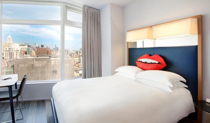 Una habitación de hotel con una almohada en forma de labios en la cama de matrimonio blanco y crujiente del hotel The Standard en Nueva York