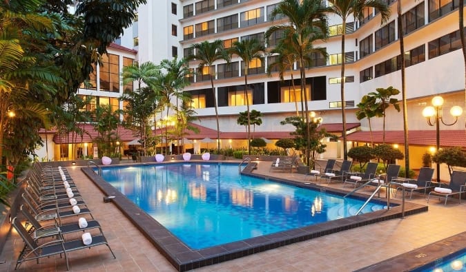 La piscina de la planta baja del York Hotel rodeada de hamacas al atardecer