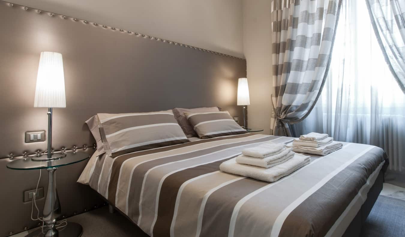 Una cama doble en una habitación de hotel decorada con estilo minimalista con diferentes tonos de gris en el Brera Prestige B&B, un hotel de Milán, Italia