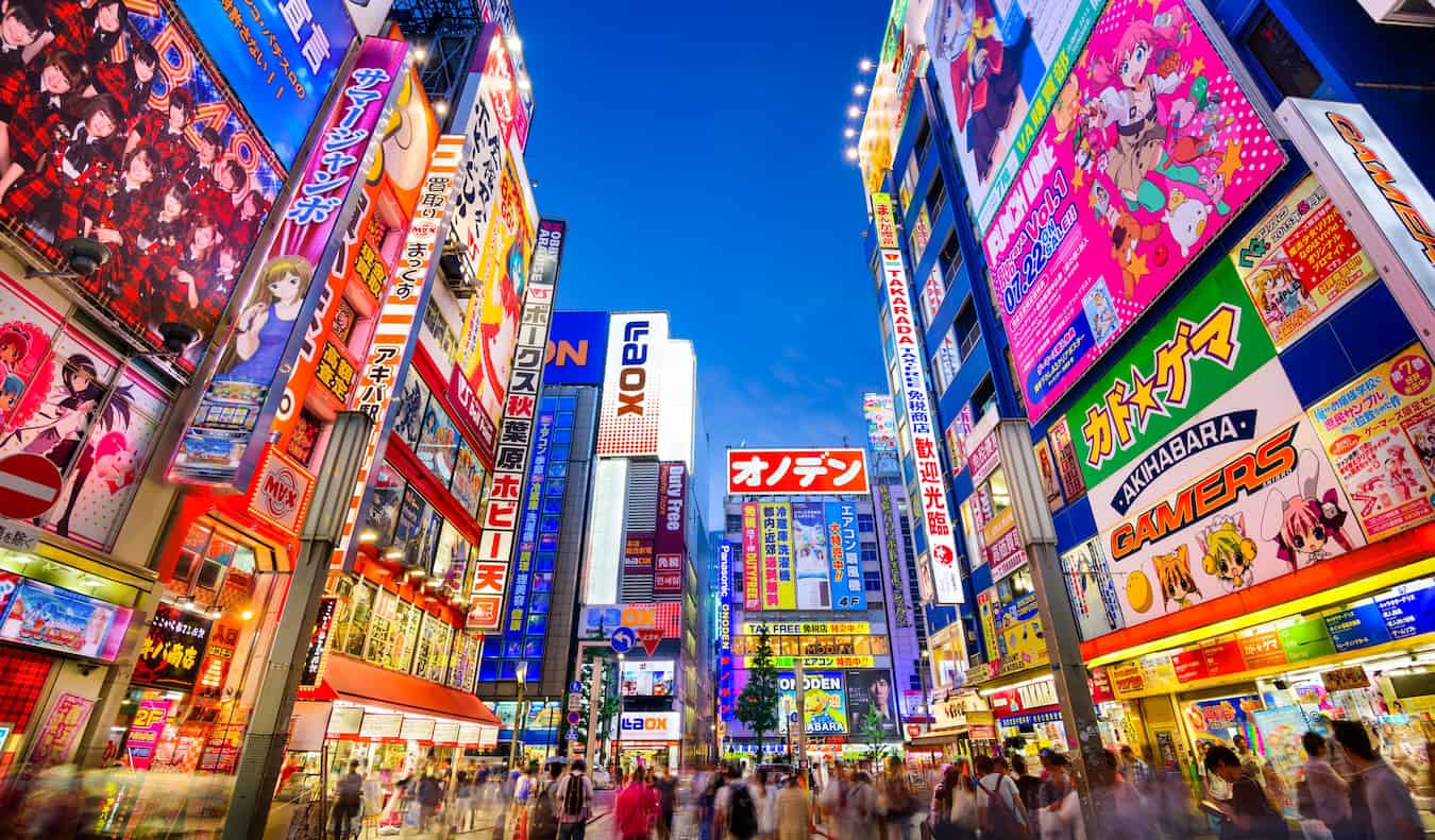 Una calle luminosa y animada iluminada por la noche con rótulos de neón en Tokio, Japón