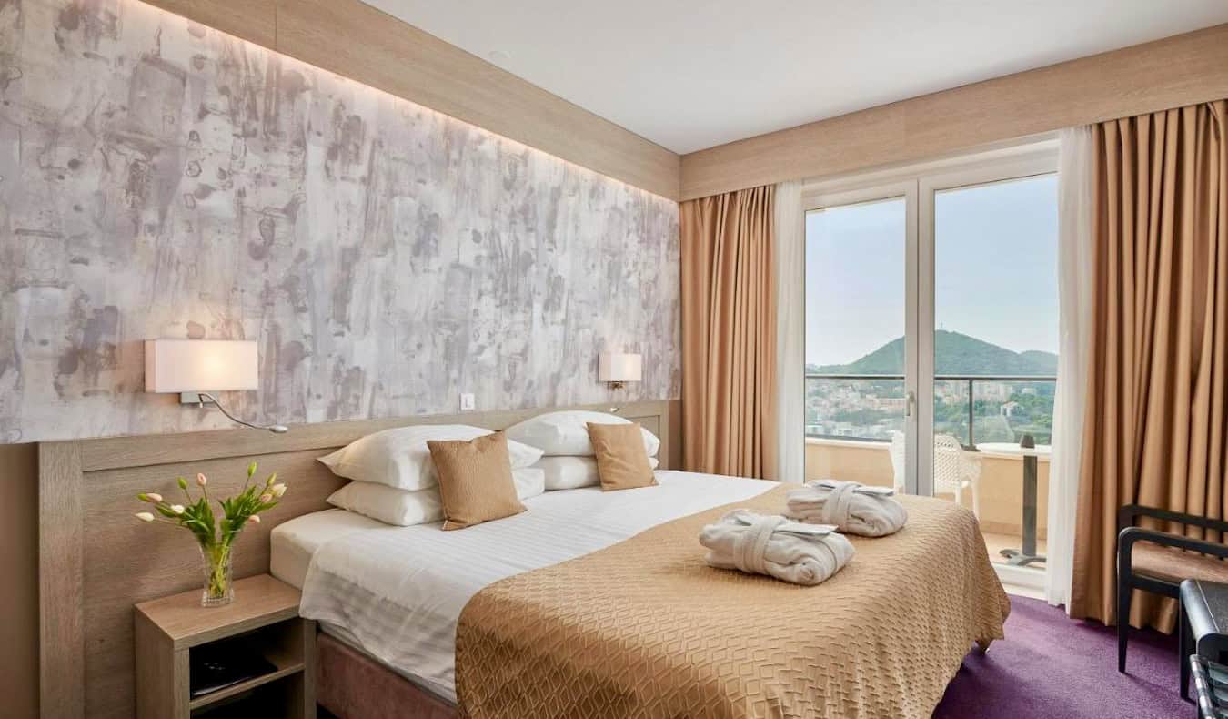 Una cama enorme y cómoda en una gran habitación de hotel en el Hotel Adria en Dubrovnik, Croacia