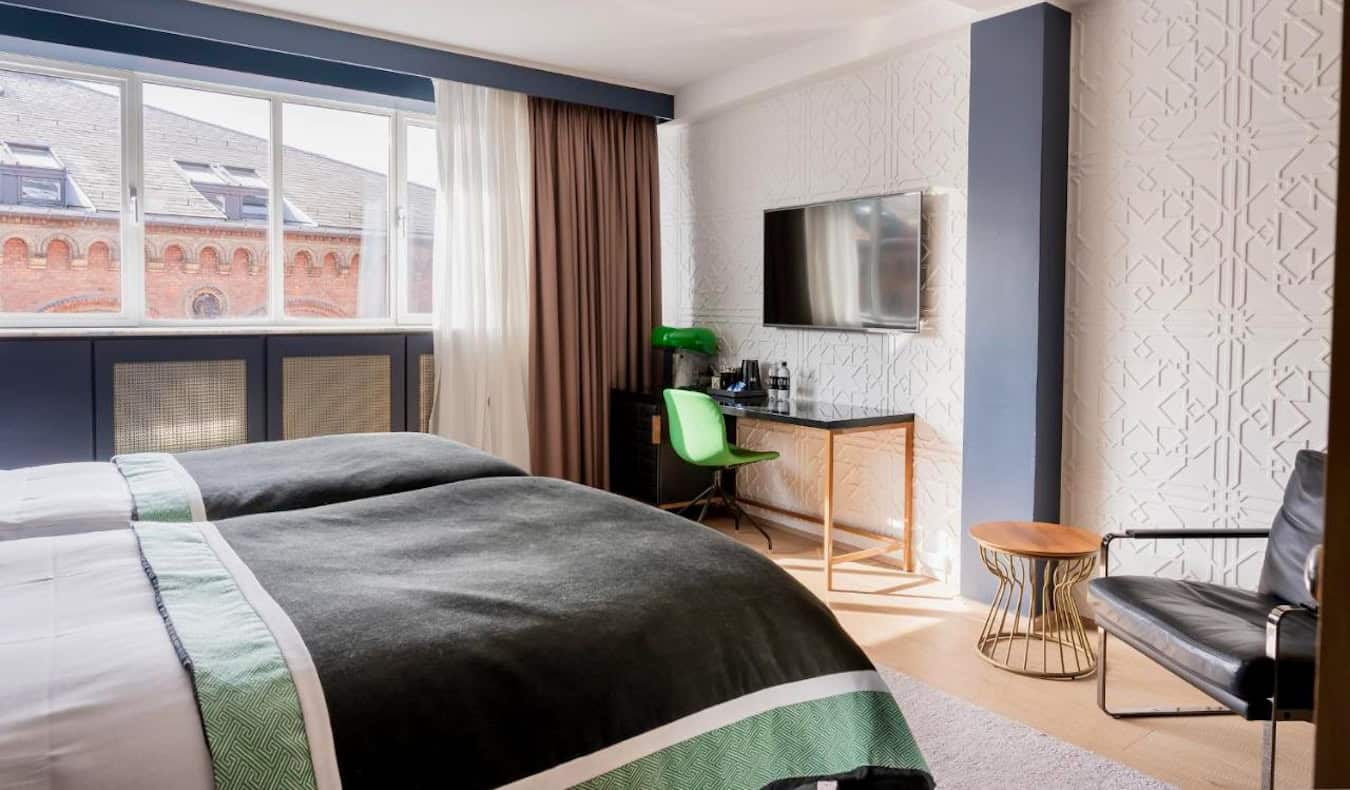 Una habitación de hotel elegante con una cama grande en el Hotel Skt Petri en Copenhague, Dinamarca