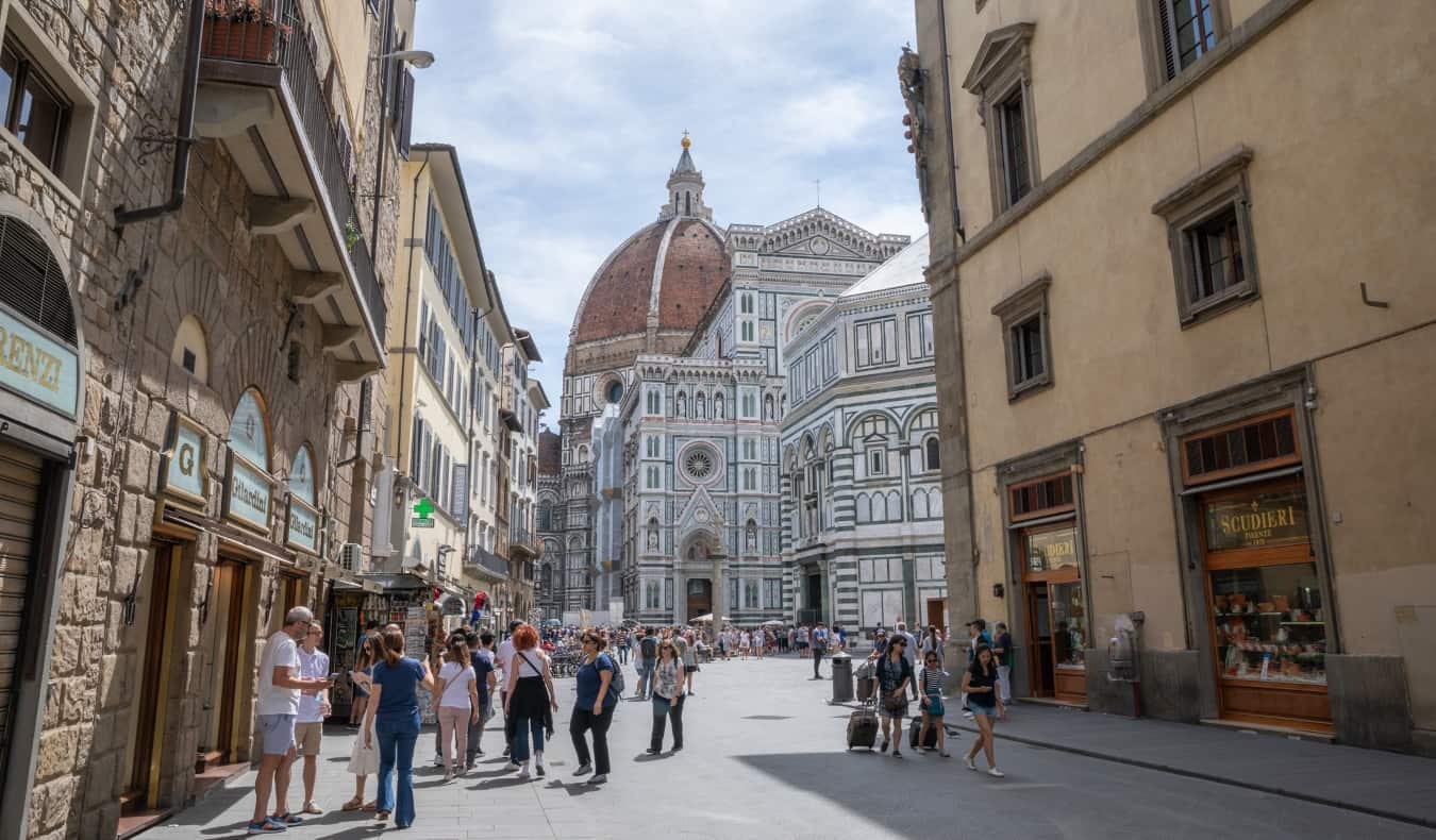 Gente callejera con la emblemática catedral del Duomo al fondo en Florencia, Italia