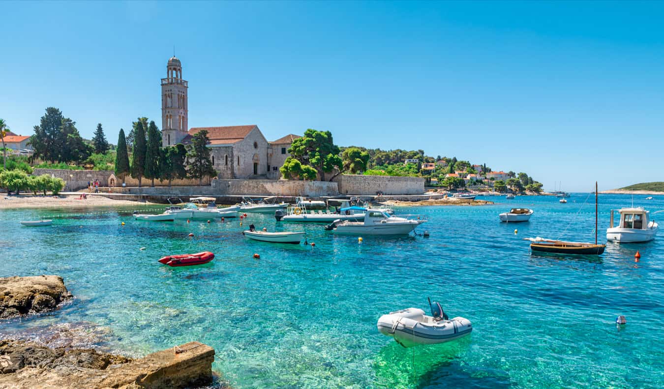 Las bellas aguas de una bahía de Hvar, Croacia, en un día soleado de verano con edificios antiguos al fondo