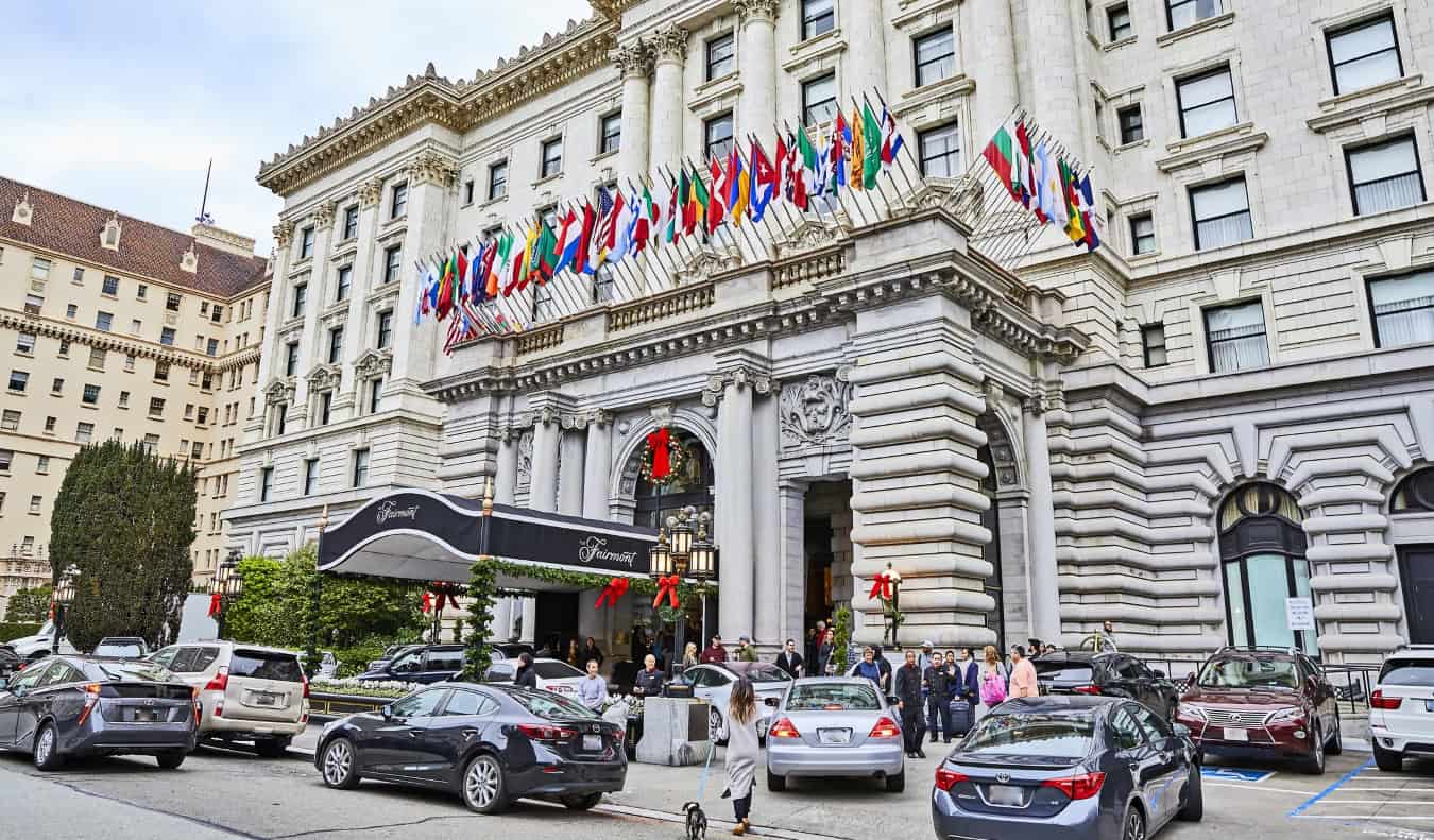 El hotel majestuoso Fairmont en Nob Hill, San Francisco, con decenas de banderas del país onen y coches de lujo aparcados enfrente