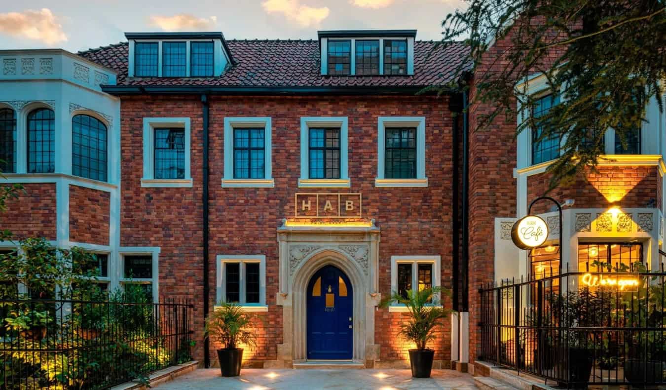 Mansión histórica de ladrillo, con una entrada y ventanas de piedra con arco, sede del hotel HAB Bogotá en Colombia